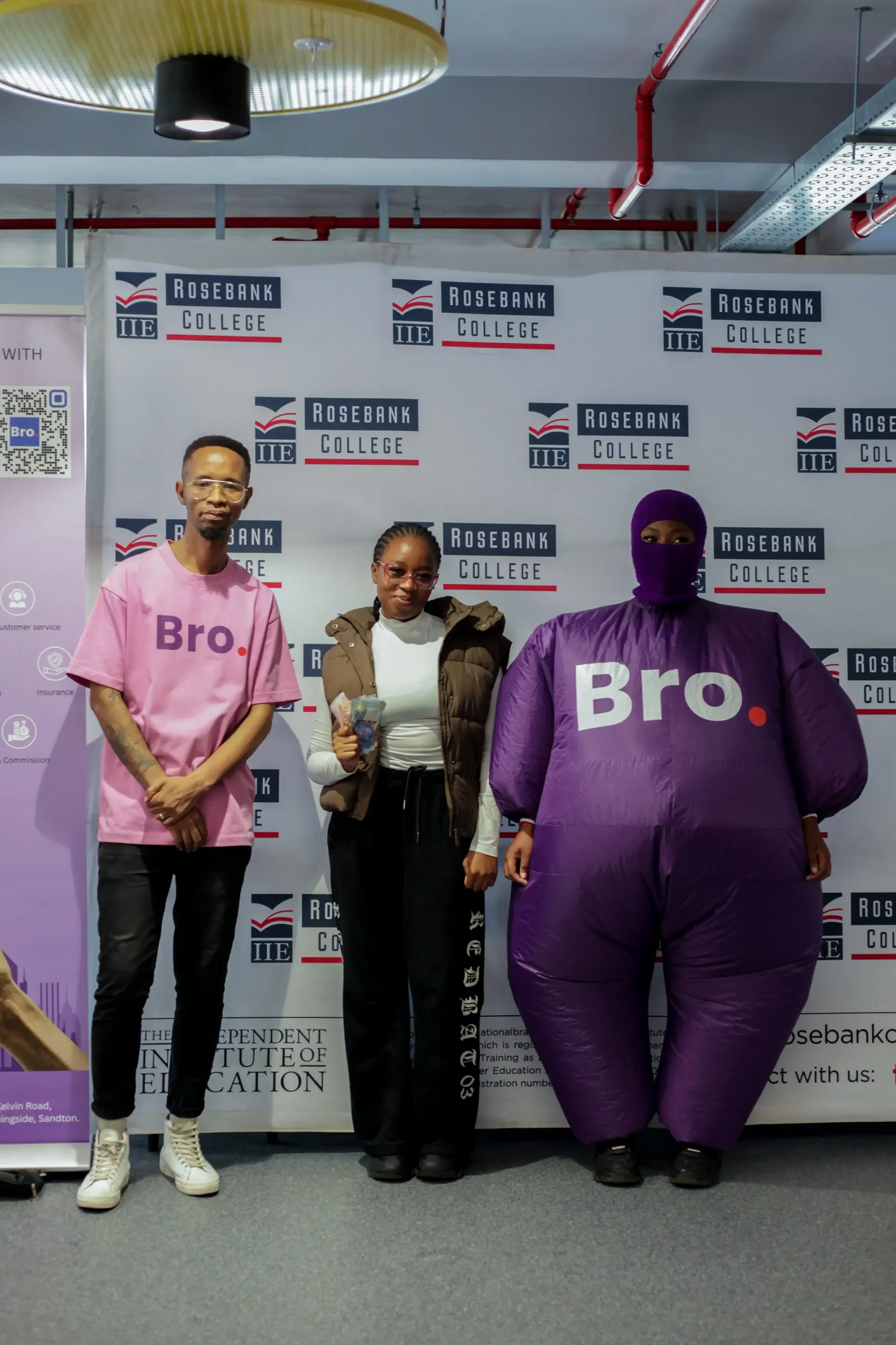 Student winner with cash prize and Bro mascot at Rosebank College