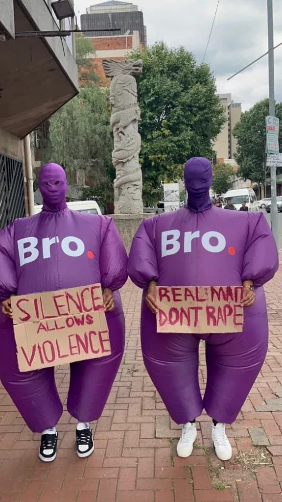 Bro mascots holding Silence Allows Violence and Real Men Do Not Rape signs