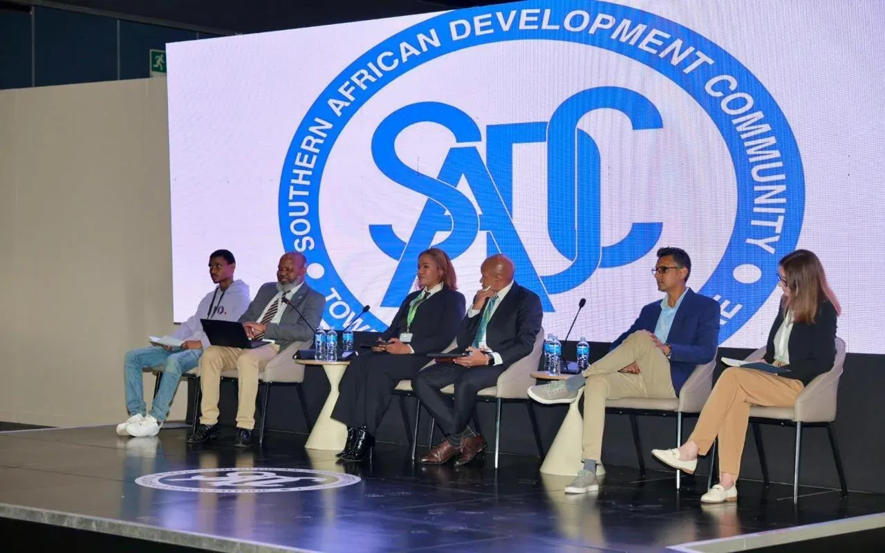 Six panellists seated on stage in front of the Southern African Development Community logo at SADC Industrialisation Week in Durban
